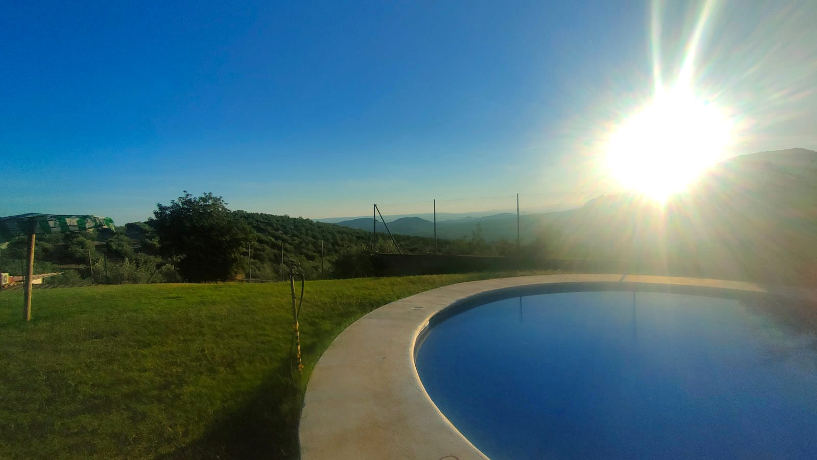 Piscina con césped natural y vistas panoramicas a las montañas en Camping El Cantonet, Albanchez de Mágina (Sierra Mágina, Jaén)