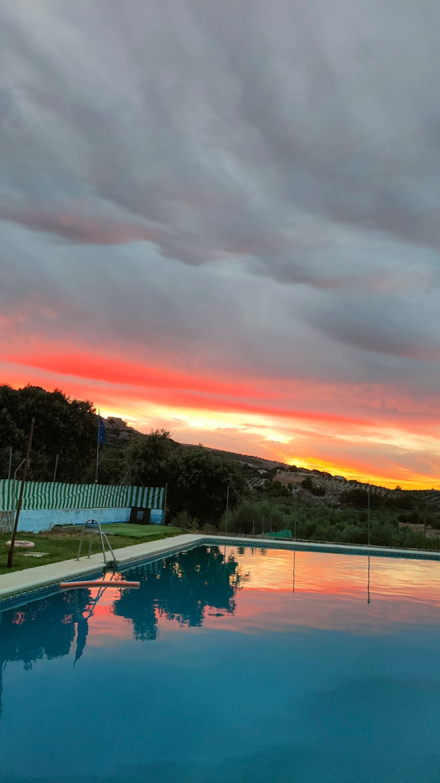 Piscina al aire libre al atardecer con vistas a la montaña en Camping El Cantonet, Albanchez de Mágina (Sierra Mágina, Jaén)