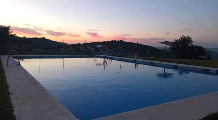 Piscina exterior al atardecer con vistas a la sierra en Camping El Cantonet, Albanchez de Mágina (Sierra Mágina, Jaén)